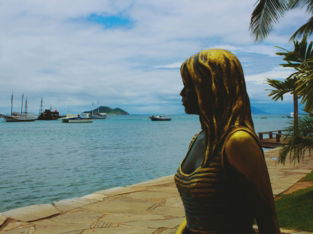 a statue of a woman standing next to a body of water